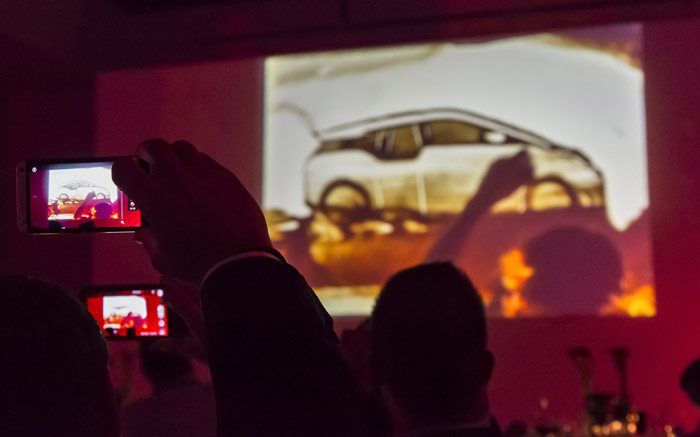 Mit dem Handy gefilmte Sandmalerei Show mit Bild des Bmw i3